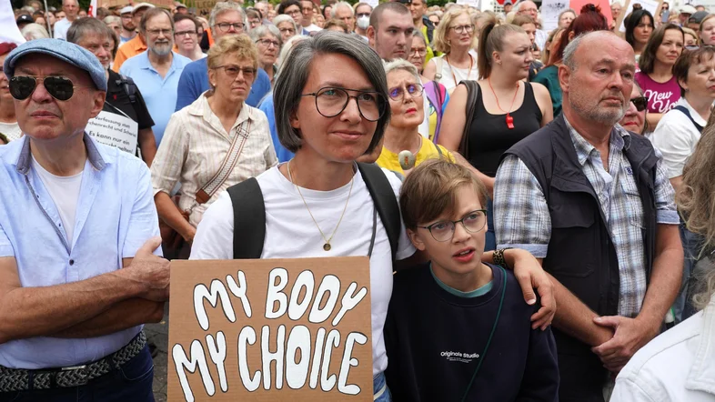 Eine Demonstrantin hält ein Plakat.