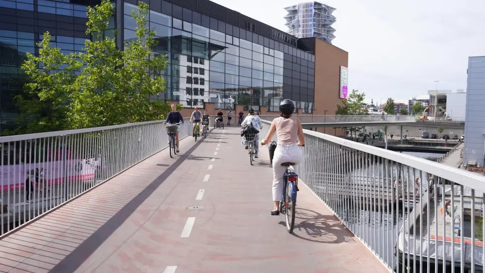 Radfahrer sind auf dem Radweg auf einer Fahrrad- und Fußgängerbrücke unterwegs.