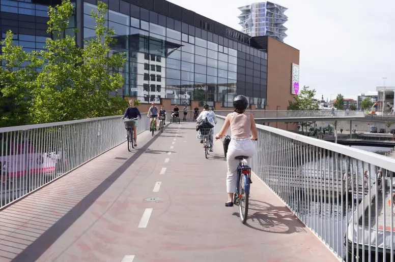 Radfahrer sind auf dem Radweg auf einer Fahrrad- und Fußgängerbrücke unterwegs.