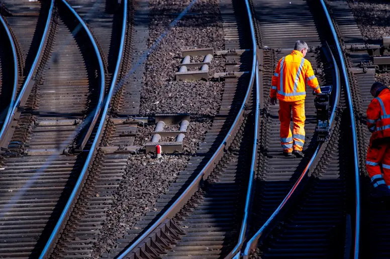 Bauarbeiter vermessen eine Schiene auf der Bahnstrecke Ludwigslust - Wismar.