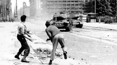 Männer werfen Steine in Richtung sowjetischer Panzer in Berlin