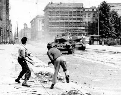 Männer werfen Steine in Richtung sowjetischer Panzer in Berlin