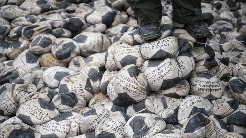 Protest mit einem Berg von platten Fußbällen gegen die WM in Katar