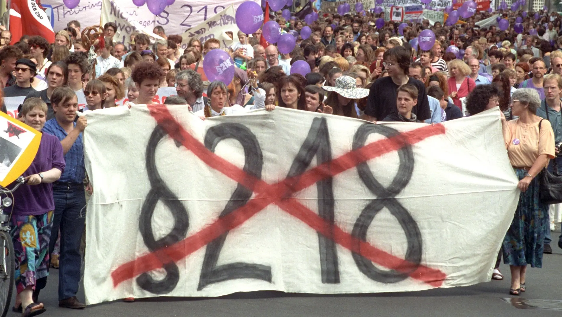 Frauen und Männer bei Protestaktion, auf großen Plakaten §218 durchgestrichen.