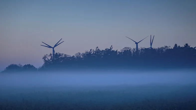 Mehrere Windräder in der Dämmerung