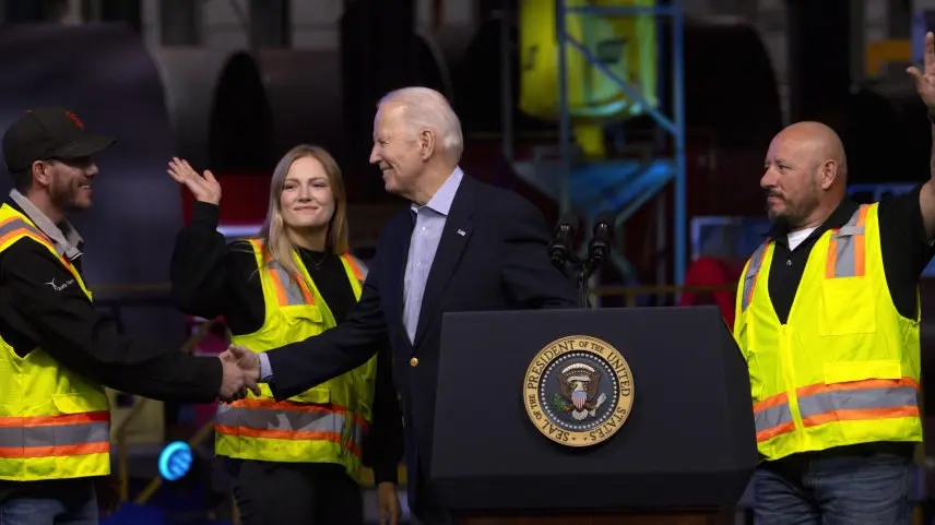 Joe Biden zu Besuch beim Anlagenbauer CS Wind. Joe Biden schüttelt die Hand eines Mitarbeiters