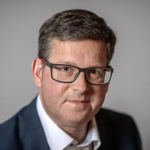Porträt von Thomas Gutschker im Anzug und mit einer Brille