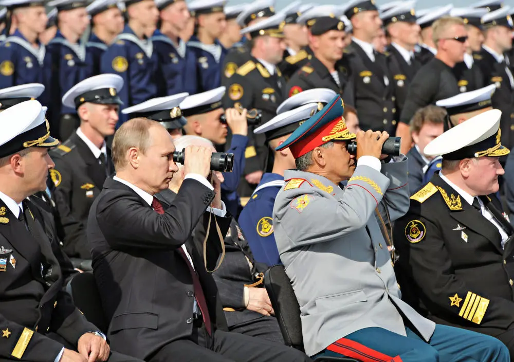 Wladimir Putin und Verteidigungsminister Sergej Schoigu während einer Militärparade, inmitten von russischen Soldaten.