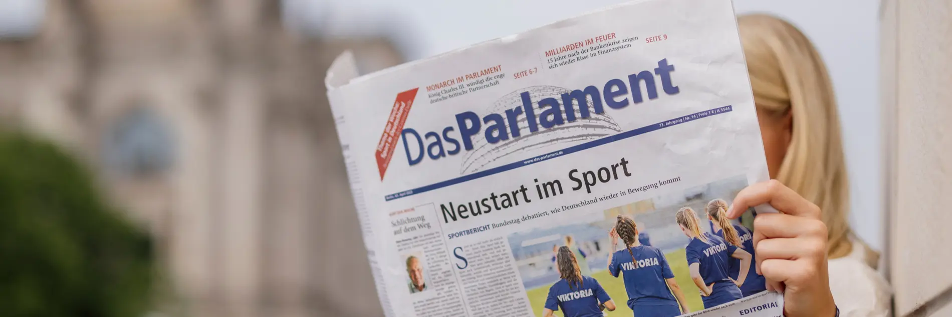 Frau liest die Wochenzeitung Das Parlament