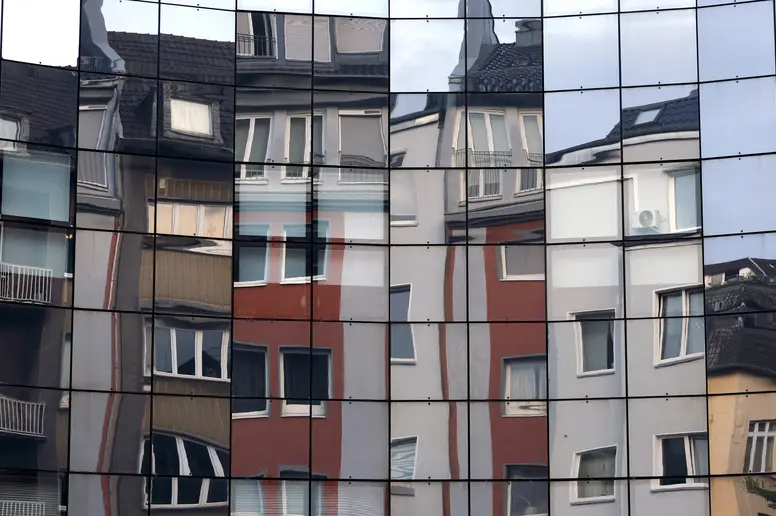 Häuser spiegeln sich in einer Fassade in der Kölner Innenstadt