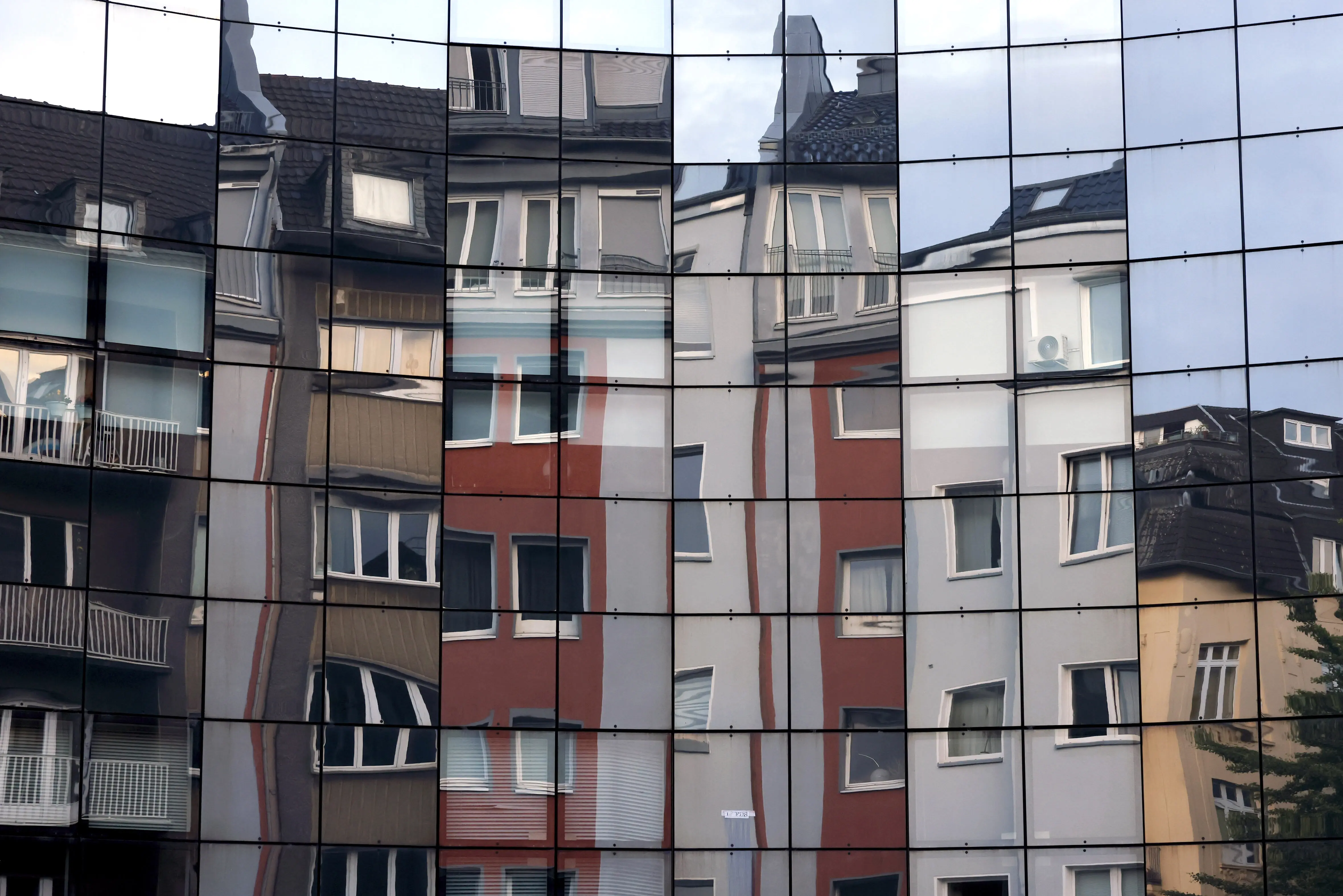 Häuser spiegeln sich in einer Fassade in der Kölner Innenstadt
