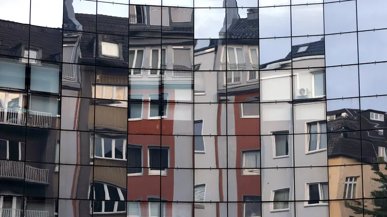 Häuser spiegeln sich in einer Fassade in der Kölner Innenstadt