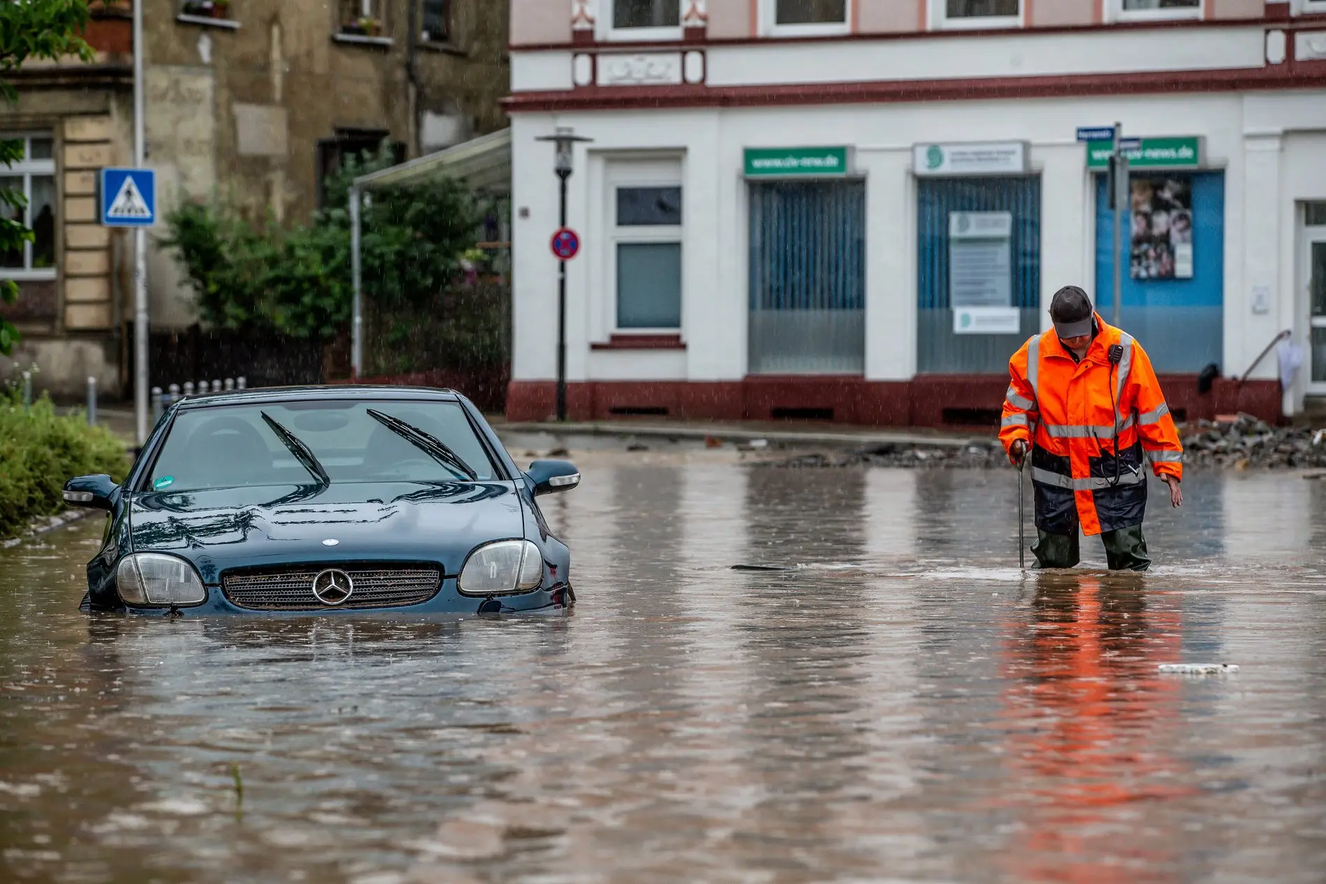Ein Mann steht auf einer überfluteten Straße im Hagener Ortsteil Hohenlimburg.
