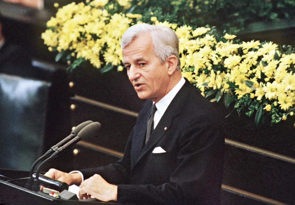 Richard von Weizsäcker am Rednerpult vor gelben Blumen
