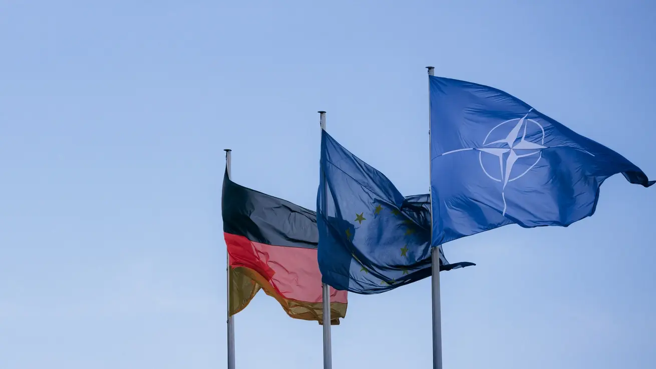Die Deutschland-, EU- und NATO-Flaggen Die Deutschland-, EU- und NATO-Flaggen nebeneinander vor dem blauen Himmel