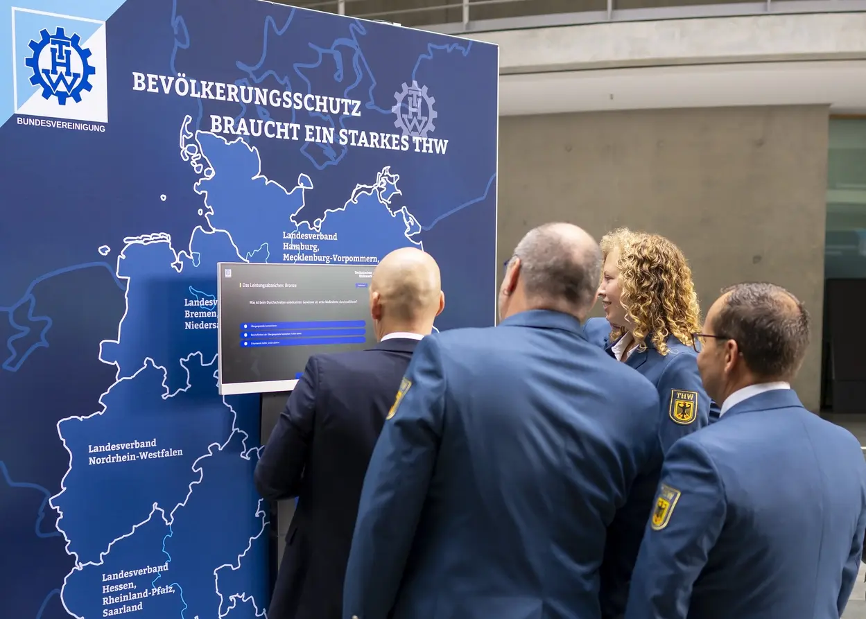 Quiz zum THW Besucherinnen und Besucher stehen vor einer Deutschlandkarte