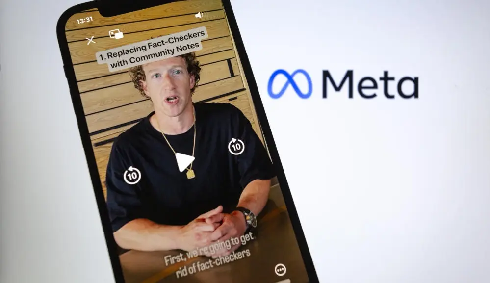Mark Zuckerberg Ein Handy zeigt ein Video von Mark Zuckerberg, daneben das Logo von Meta