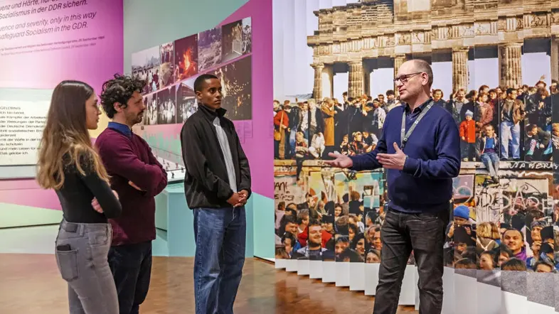 Drei Besucher des Deutschen Historischen Museums mit einem Mitarbeiter