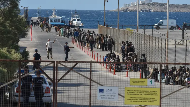 Migranten stehen am Hafen von Lavrio in einer Reihe