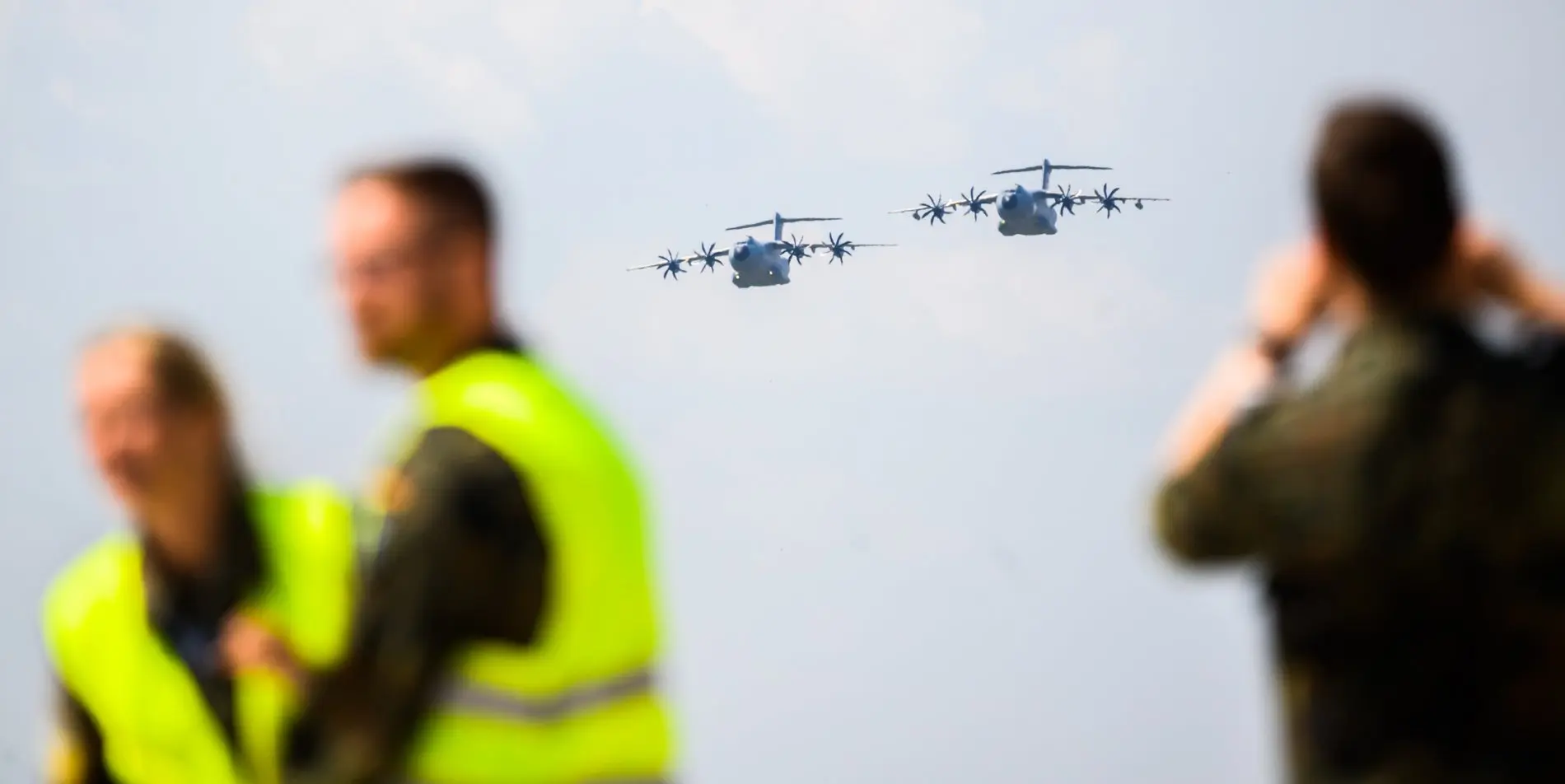 Zwei Personen mit Warnweste, ein Mann mit Kamera, dazwischen zwei Airbus A400M Zwei Personen mit Warnweste, ein Mann mit Kamera, dazwischen zwei Airbus A400M