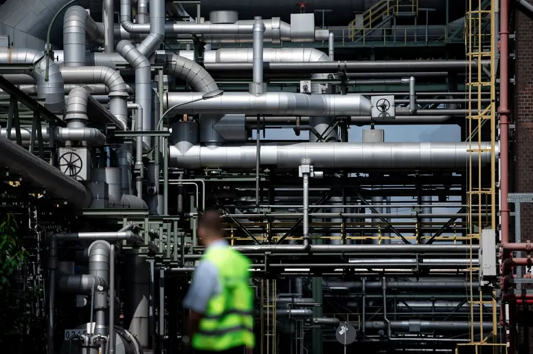 Mitarbeiter steht vor Rohren auf dem Gelände des Evonik-Chemieparks