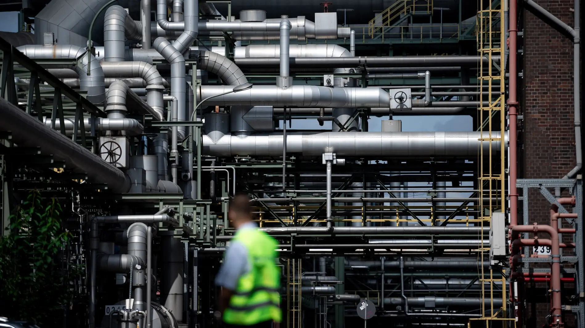 Mitarbeiter steht vor Rohren auf dem Gelände des Evonik-Chemieparks