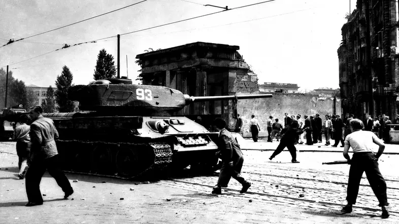 Schwarz-weiß Foto Menschen werfen Steine in Richtung eines sowjetischen Panzers