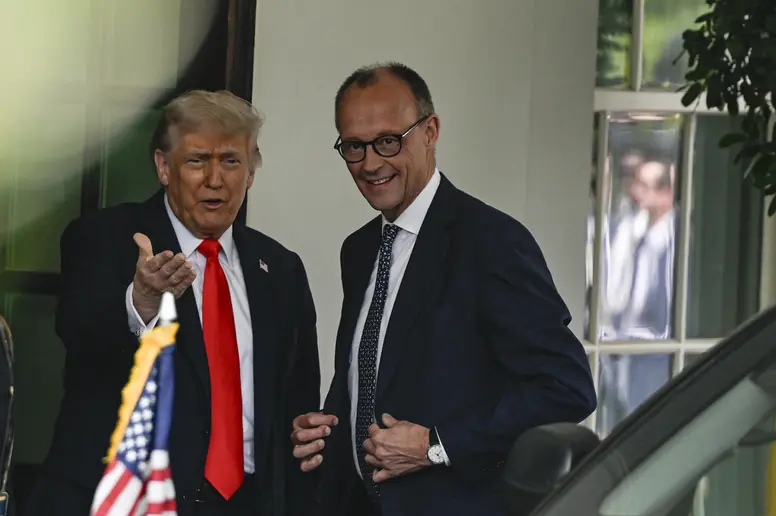 Donald Trump und Friedrich Merz schauen in die Kamera