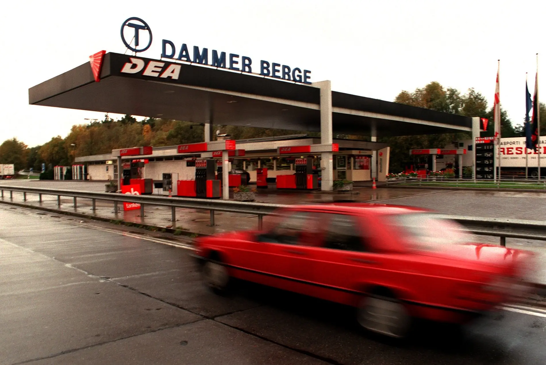 Tankstelle in Deutschland ein rotes Auto fährt vorbei
