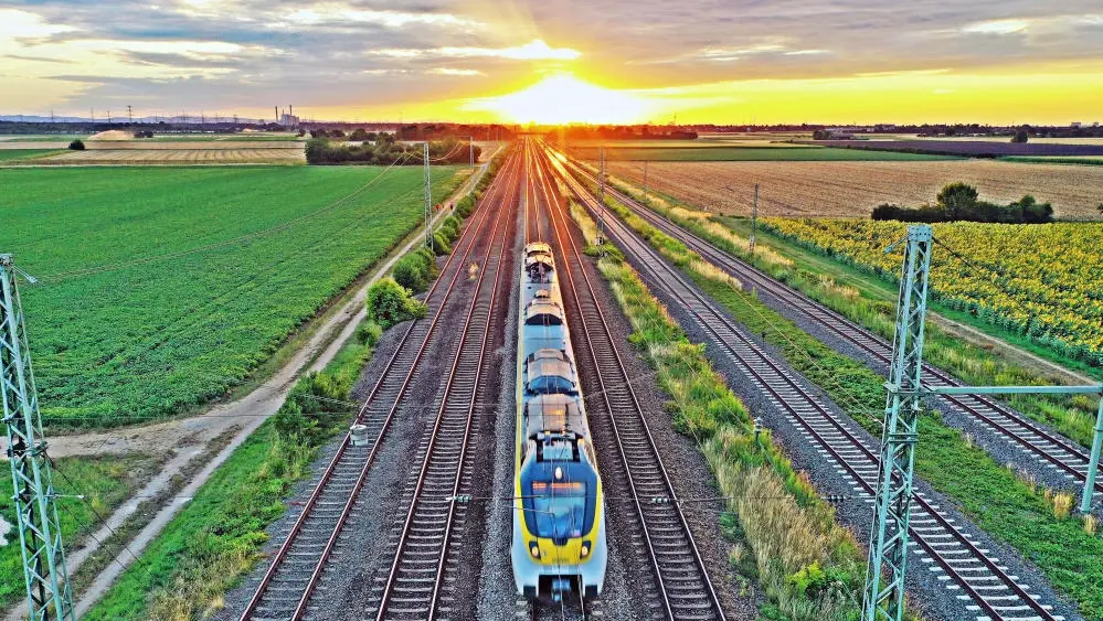 Ein Zug fährt, Sonnenuntergang am Horizont.
