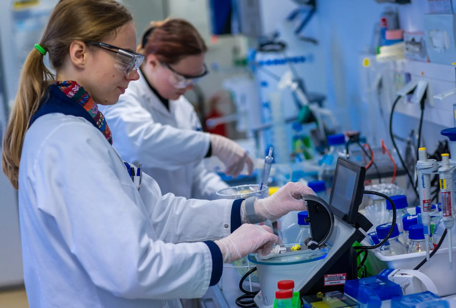 Zwei Wissenschaftlerinnen arbeiten mit Schutzbrillen in einem Labor.