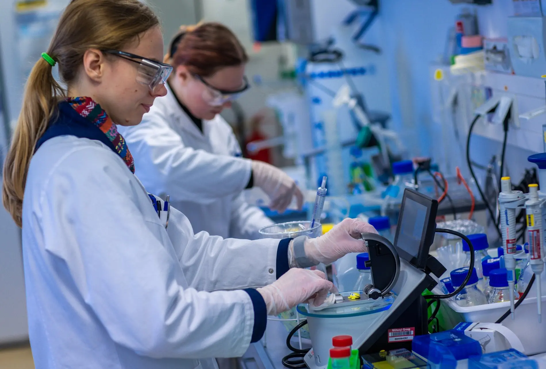 Die Forschung soll sich international stärker vernetzen. Zwei Wissenschaftlerinnen arbeiten mit Schutzbrillen in einem Labor.