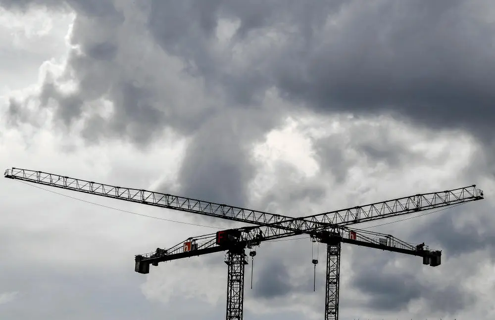 Aktuelle Wirtschaftsdaten deuten eine deutliche Eintrübung des Konjunkturhimmels an. Zwei überkreuzte Baukräne vor grauem Himmel.