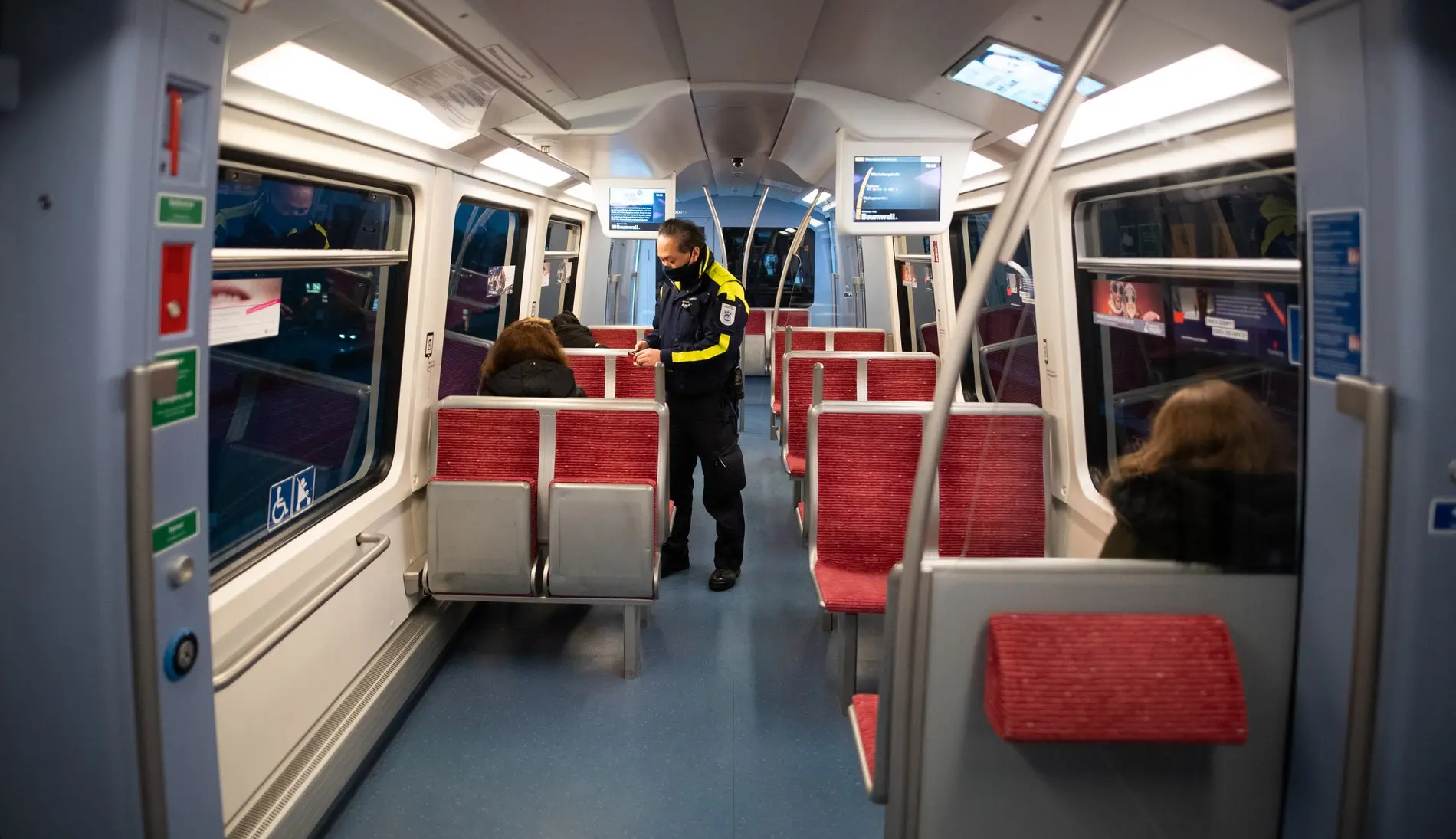 Ein Mitarbeiter kontrolliert in einem Zug die Fahrkarten.