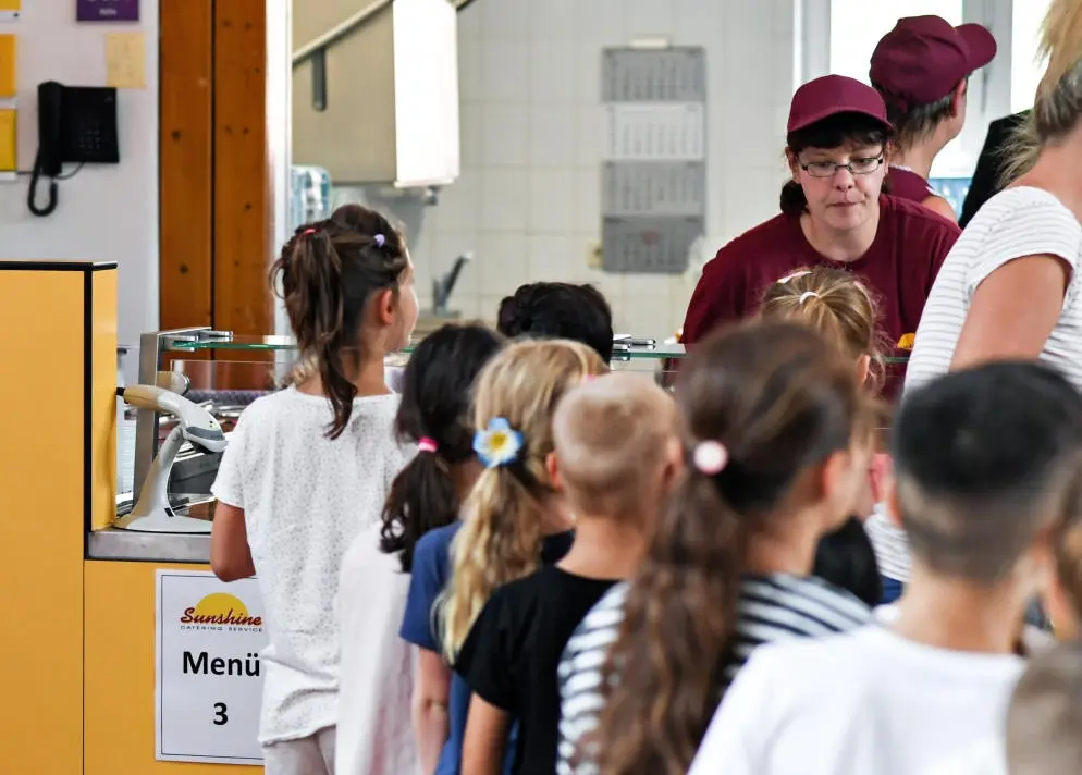 Schüler stehen in der Schlange vor der Essensausgabe