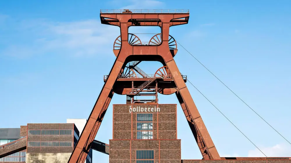 Das rote Doppelbockfördergerüst ragt über das Gelände der Zeche Zollverein empor