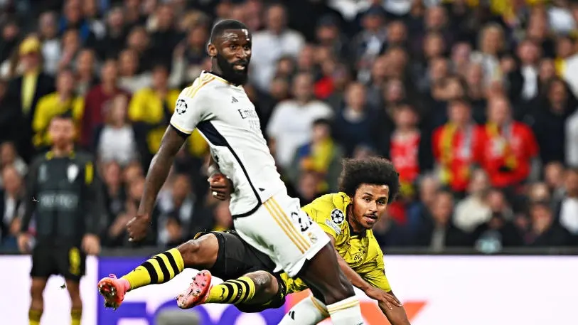 Antonio Ruediger und Karim Adeyemi auf einem Fußballfeld während eines Spiels