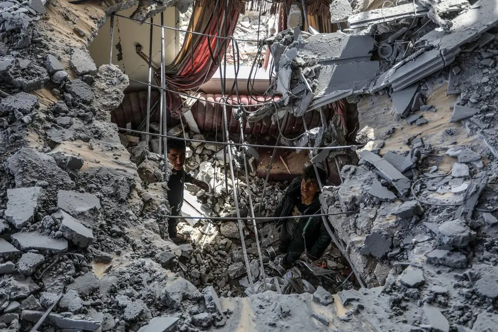 Männer durchsuchen ein eingestürztes Haus in Rafah