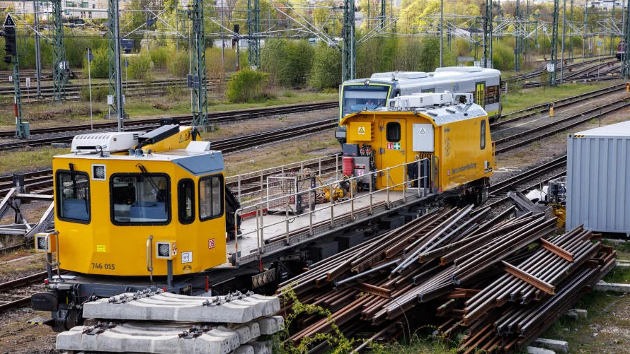 Ein Schienenfahrzeug der Deutschen Bahn steht neben zahlreichen Gleiselementen.