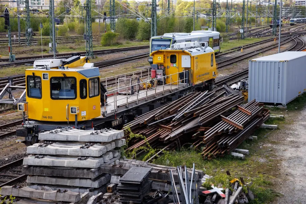 Ein Schienenfahrzeug der Deutschen Bahn steht neben zahlreichen Gleiselementen.
