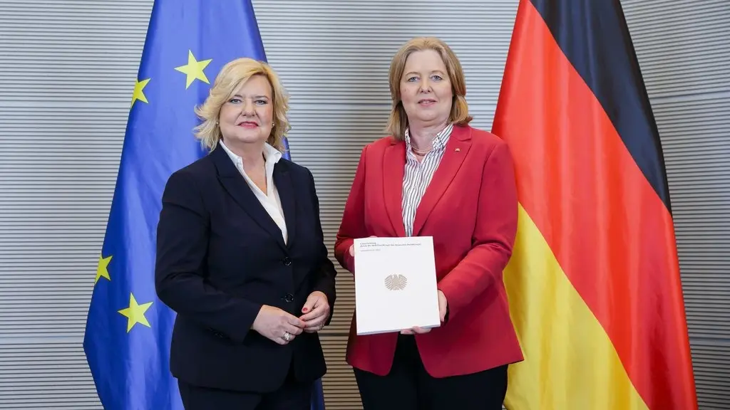 Wehrbericht 2023 übergeben Wehrbeauftragte Eva Högl und Bundestagspräsidentin Bärbel Bas vor Flaggen