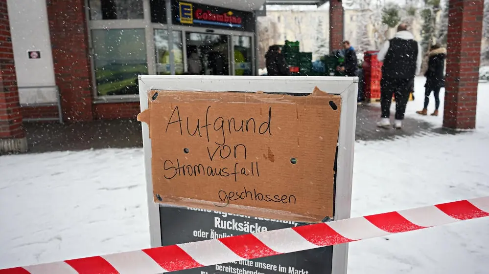 Wo jetzt einkaufen für’s Wochenende? Menschen  stehen am ersten Tag des Stromausfalls vor einem geschlossenen Supermarkt in Berlin-Zehlendorf.