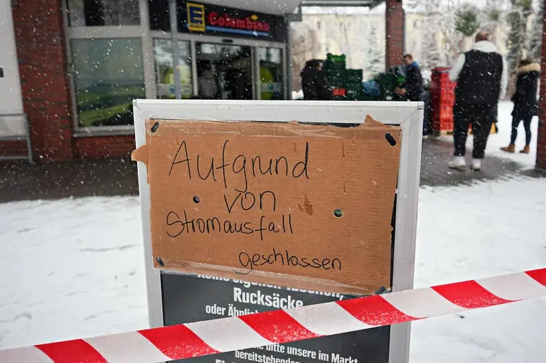 Wo jetzt einkaufen für’s Wochenende? Menschen  stehen am ersten Tag des Stromausfalls vor einem geschlossenen Supermarkt in Berlin-Zehlendorf.