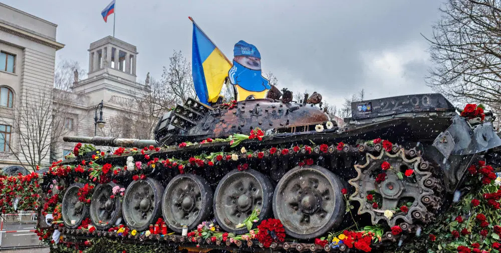 Ein mit Blumen geschmückter Panzer mit ukrainischer Flagge