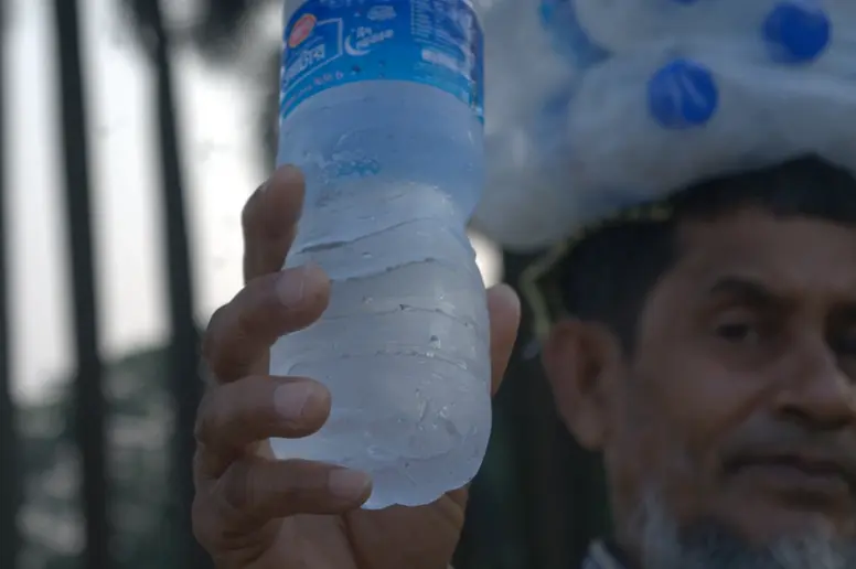 Ein Mann hält eine kalte Wasserflasche in die Kamera