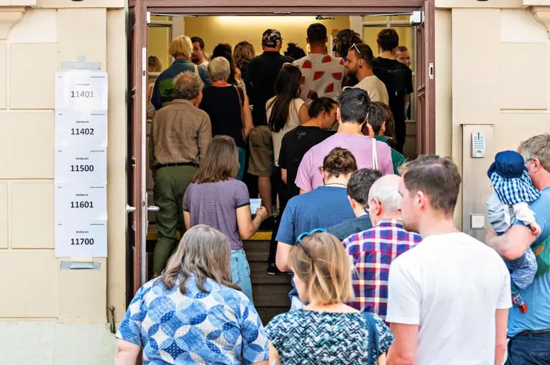 Wähler stehen vor der Stimmabgabe in Sachsen vor einem Wahllokal an