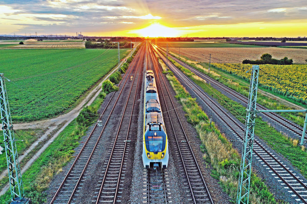 Ein Zug fährt, Sonnenuntergang am Horizont.